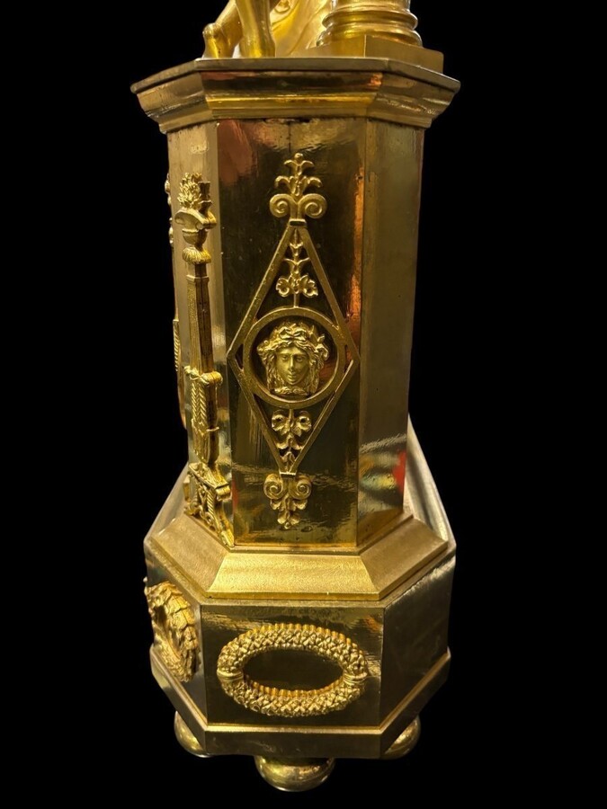 Nice Empire period clock in matt and bright gilt bronze depicting a lady playing guitar with an angel. In very good condition, the movement has not been checked. The balance wheel is present. Dimensions: Width: 31.5 cm Height: 43 cm Depth : 13 cm