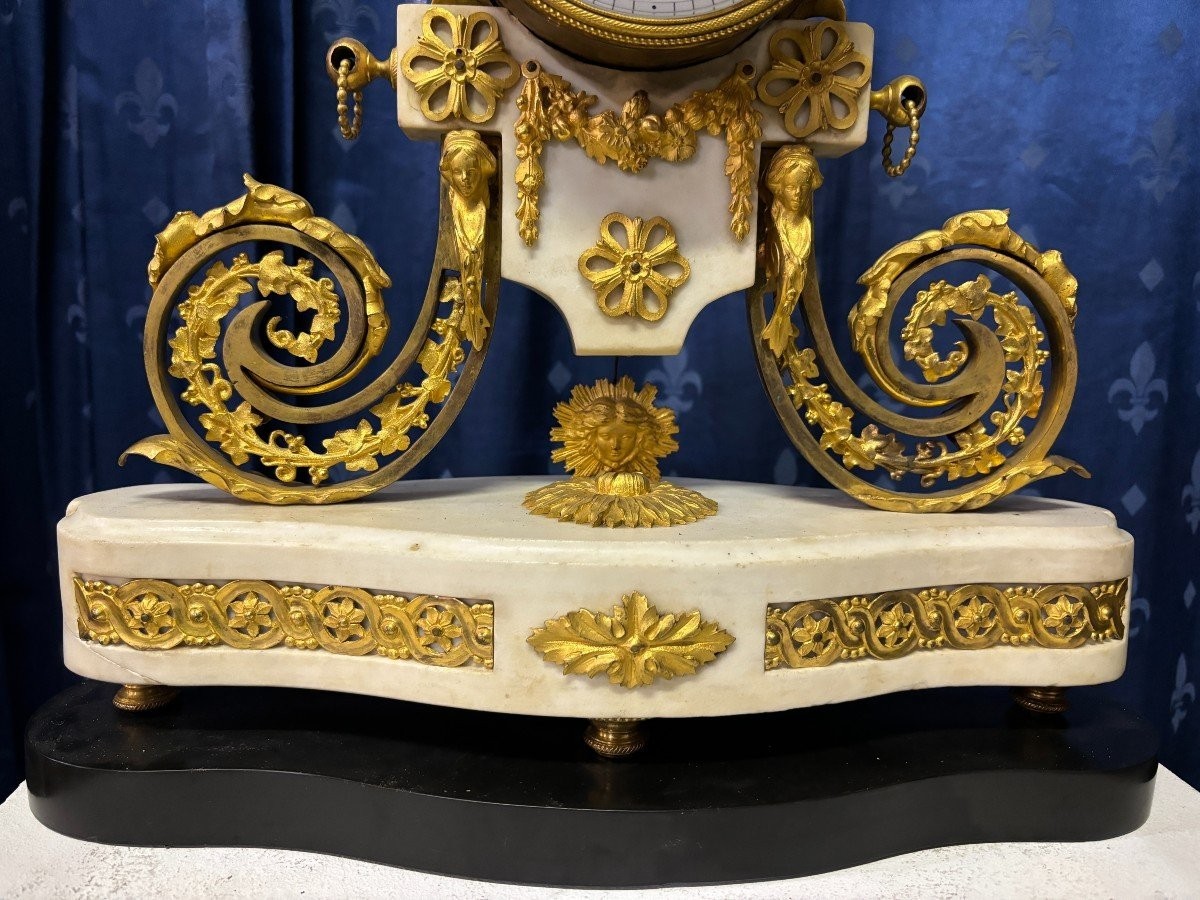 Nice Louis XVI style clock in marble and gilt bronze 18th century Elegant mantel clock decorated with gilt bronze ornaments, women's heads, birds, foliage and its original sundial. Minor old restoration to the marble base. Dimensions : Height: 41 cm