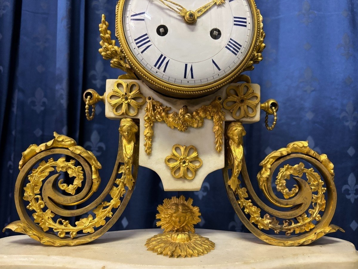 Nice Louis XVI style clock in marble and gilt bronze 18th century Elegant mantel clock decorated with gilt bronze ornaments, women's heads, birds, foliage and its original sundial. Minor old restoration to the marble base. Dimensions : Height: 41 cm