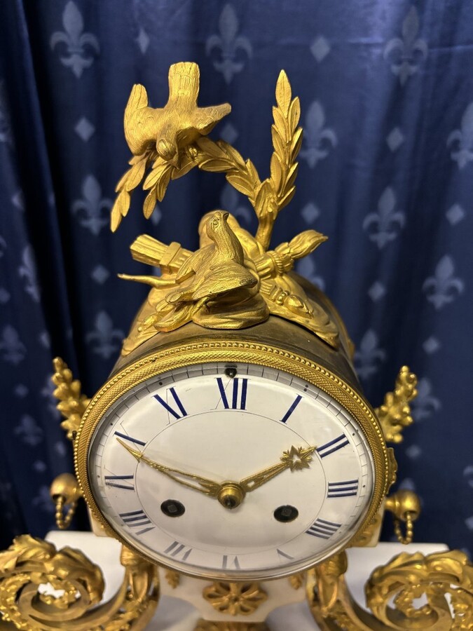 Nice Louis XVI style clock in marble and gilt bronze 18th century Elegant mantel clock decorated with gilt bronze ornaments, women's heads, birds, foliage and its original sundial. Minor old restoration to the marble base. Dimensions : Height: 41 cm