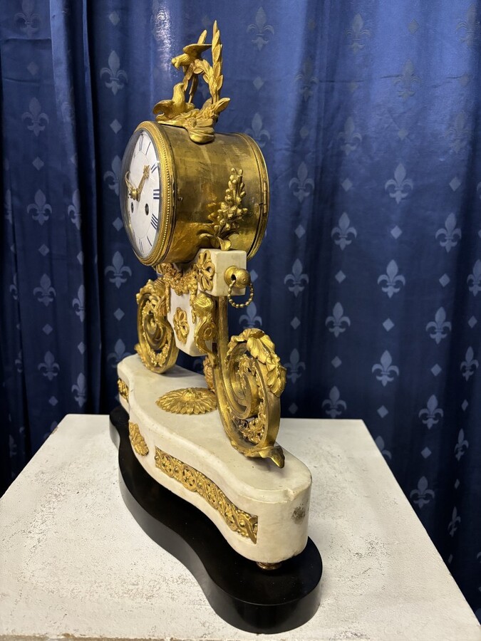 Nice Louis XVI style clock in marble and gilt bronze 18th century Elegant mantel clock decorated with gilt bronze ornaments, women's heads, birds, foliage and its original sundial. Minor old restoration to the marble base. Dimensions : Height: 41 cm