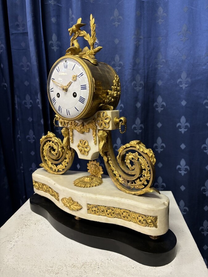 Nice Louis XVI style clock in marble and gilt bronze 18th century Elegant mantel clock decorated with gilt bronze ornaments, women's heads, birds, foliage and its original sundial. Minor old restoration to the marble base. Dimensions : Height: 41 cm