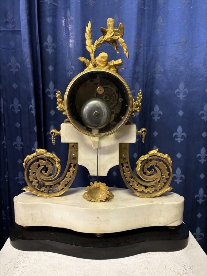 Nice Louis XVI style clock in marble and gilt bronze 18th century Elegant mantel clock decorated with gilt bronze ornaments, women's heads, birds, foliage and its original sundial. Minor old restoration to the marble base. Dimensions : Height: 41 cm