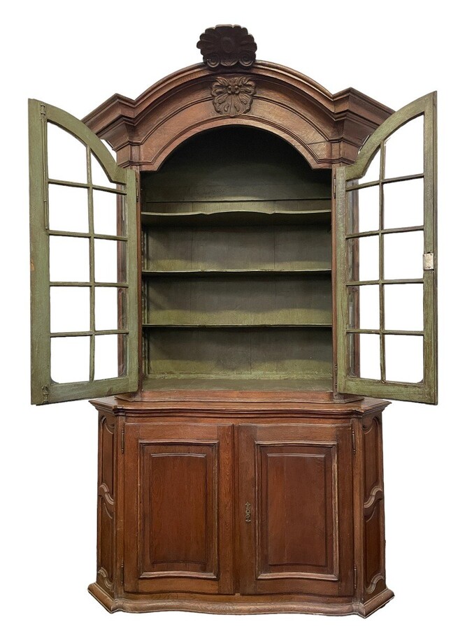Oak 18th century display cabinet with 4 curved doors. Beautiful large 18th century Flemish display cabinet with curved fronts at top and bottom and a carved double shell at top and glass on the sides The cabinet is made up of 2 parts
