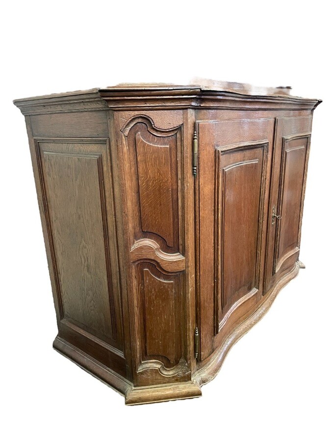 Oak 18th century display cabinet with 4 curved doors. Beautiful large 18th century Flemish display cabinet with curved fronts at top and bottom and a carved double shell at top and glass on the sides The cabinet is made up of 2 parts