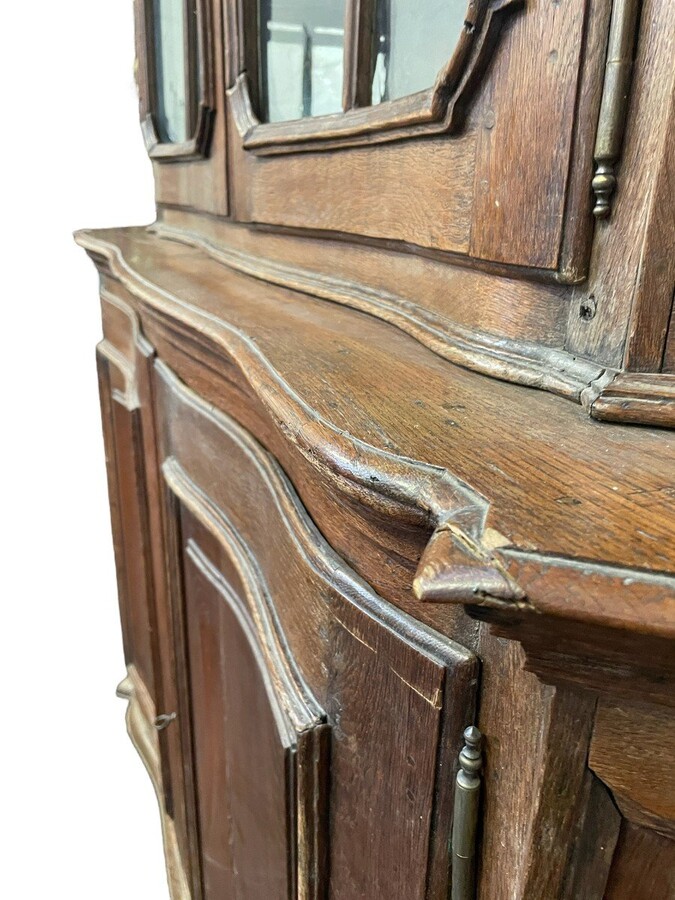 Oak 18th century display cabinet with 4 curved doors. Beautiful large 18th century Flemish display cabinet with curved fronts at top and bottom and a carved double shell at top and glass on the sides The cabinet is made up of 2 parts