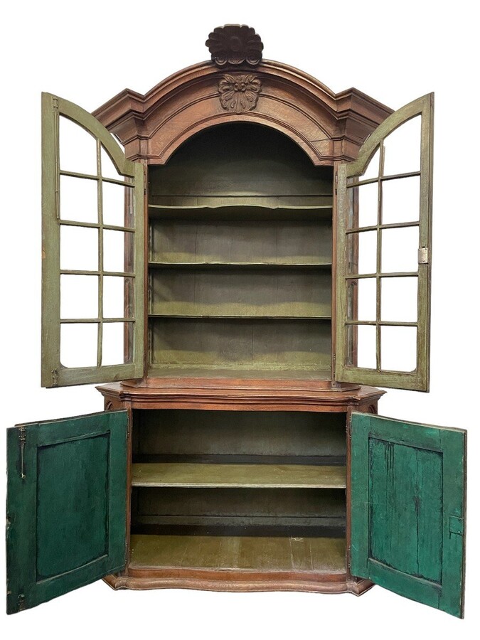 Oak 18th century display cabinet with 4 curved doors. Beautiful large 18th century Flemish display cabinet with curved fronts at top and bottom and a carved double shell at top and glass on the sides The cabinet is made up of 2 parts