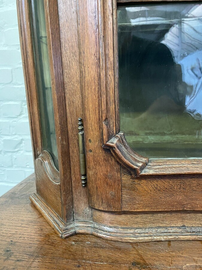 Oak 18th century display cabinet with 4 curved doors. Beautiful large 18th century Flemish display cabinet with curved fronts at top and bottom and a carved double shell at top and glass on the sides The cabinet is made up of 2 parts