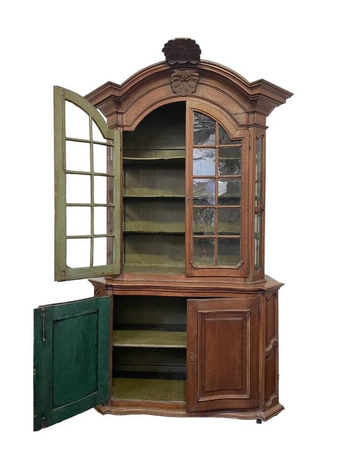 Oak 18th century display cabinet with 4 curved doors. Beautiful large 18th century Flemish display cabinet with curved fronts at top and bottom and a carved double shell at top and glass on the sides The cabinet is made up of 2 parts