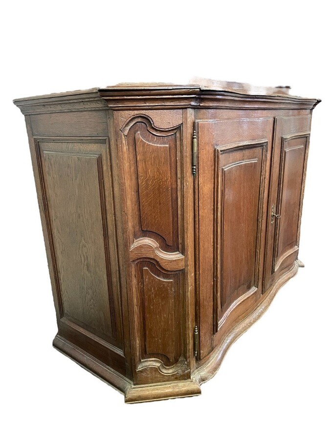 Oak 18th century display cabinet with 4 curved doors. Beautiful large 18th century Flemish display cabinet with curved fronts at top and bottom and a carved double shell at top and glass on the sides The cabinet is made up of 2 parts