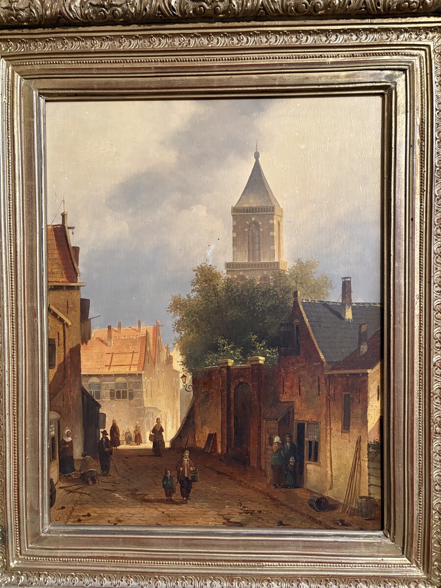 Painting ‘View of an Old Dutch Town’ oil on panel, 19th century Decorative painting in a large gilded frame depicting an old town, a street with old houses, a church, a gate with a municipal garden and various figures. 