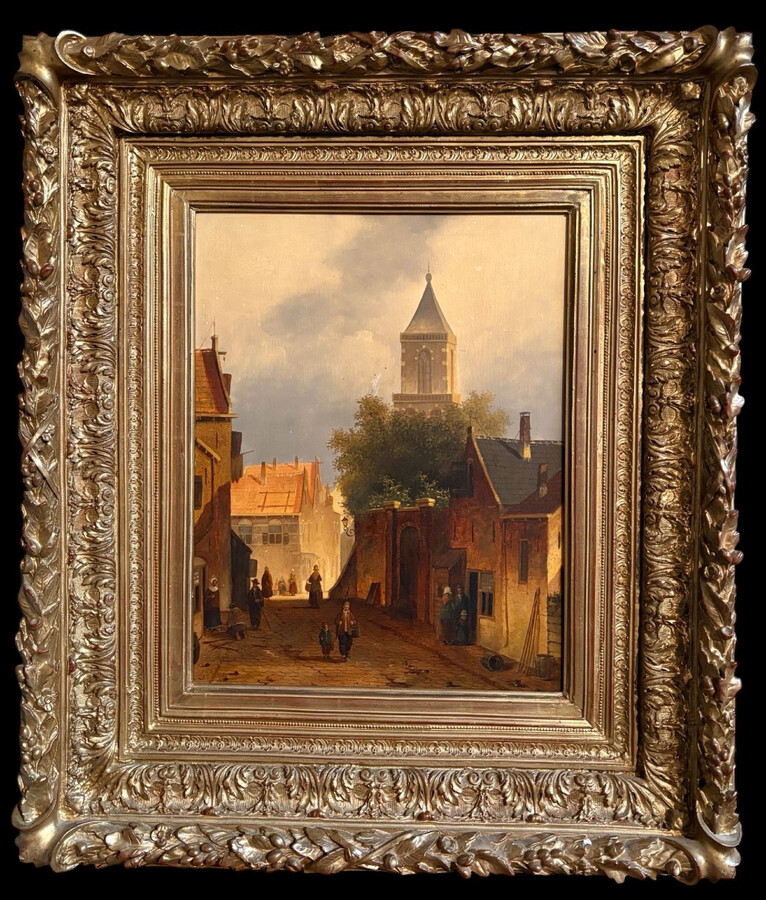 Painting ‘View of an Old Dutch Town’ oil on panel, 19th century Decorative painting in a large gilded frame depicting an old town, a street with old houses, a church, a gate with a municipal garden and various figures.