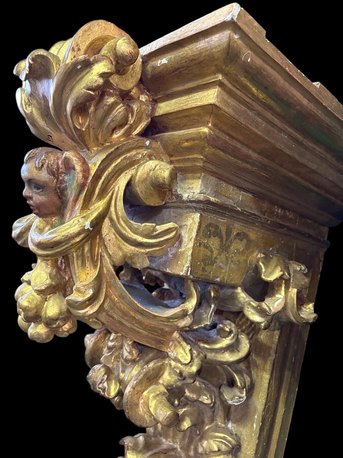 Pair of 17th-century Italian Baroque consoles. Decorative consoles carved in wood, gilded/polychrome, with garlands, fruit, angel heads and decorative ornaments. Ideal for creating a beautiful wall console. Both are in good condition, with normal signs of