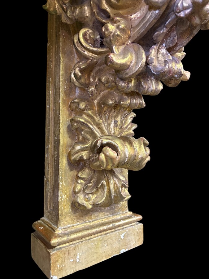 Pair of 17th-century Italian Baroque consoles. Decorative consoles carved in wood, gilded/polychrome, with garlands, fruit, angel heads and decorative ornaments. Ideal for creating a beautiful wall console. Both are in good condition, with normal signs of