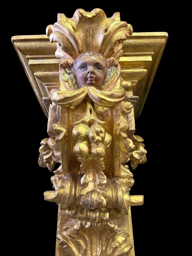 Pair of 17th-century Italian Baroque consoles. Decorative consoles carved in wood, gilded/polychrome, with garlands, fruit, angel heads and decorative ornaments. Ideal for creating a beautiful wall console. Both are in good condition, with normal signs of