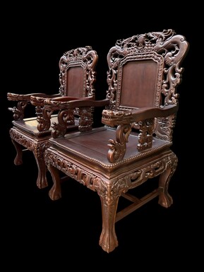 Pair of Asian solid wood armchairs, 20th century Decorative armchairs adorned with magnificent dragons and dragon heads as armrests. Dimensions: Height: 119 cm Width: 76 cm Depth: 67 cm Heavy solid wood armchairs in good condition, 20th century.