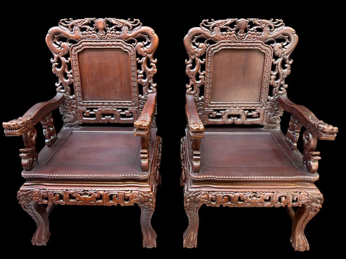 Pair of Asian solid wood armchairs, 20th century Decorative armchairs adorned with magnificent dragons and dragon heads as armrests. Dimensions: Height: 119 cm Width: 76 cm Depth: 67 cm Heavy solid wood armchairs in good condition, 20th century.