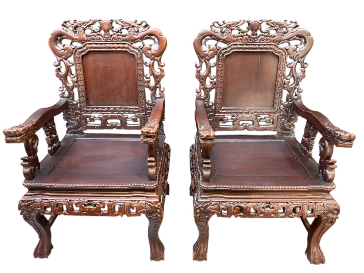 Pair of Asian solid wood armchairs, 20th century Decorative armchairs adorned with magnificent dragons and dragon heads as armrests. Dimensions: Height: 119 cm Width: 76 cm Depth: 67 cm Heavy solid wood armchairs in good condition, 20th century.