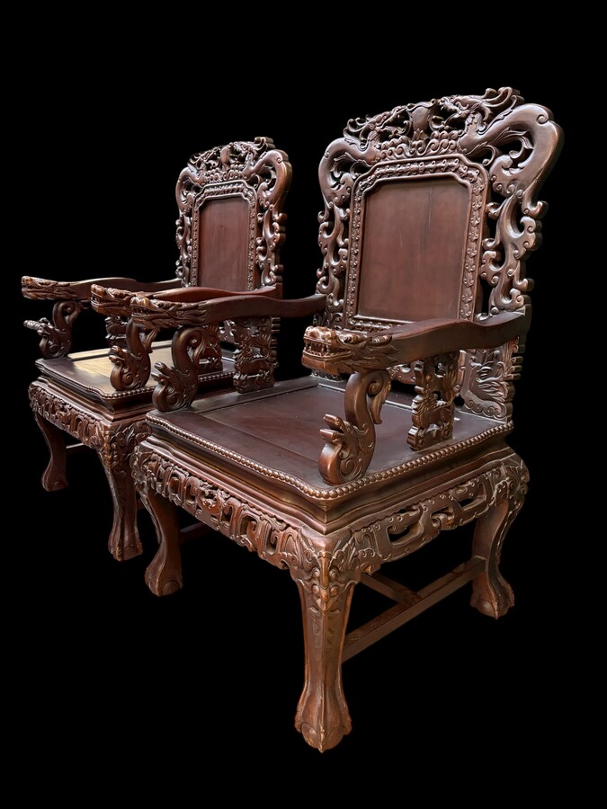 Pair of Asian solid wood armchairs, 20th century Decorative armchairs adorned with magnificent dragons and dragon heads as armrests. Dimensions: Height: 119 cm Width: 76 cm Depth: 67 cm Heavy solid wood armchairs in good condition, 20th century.