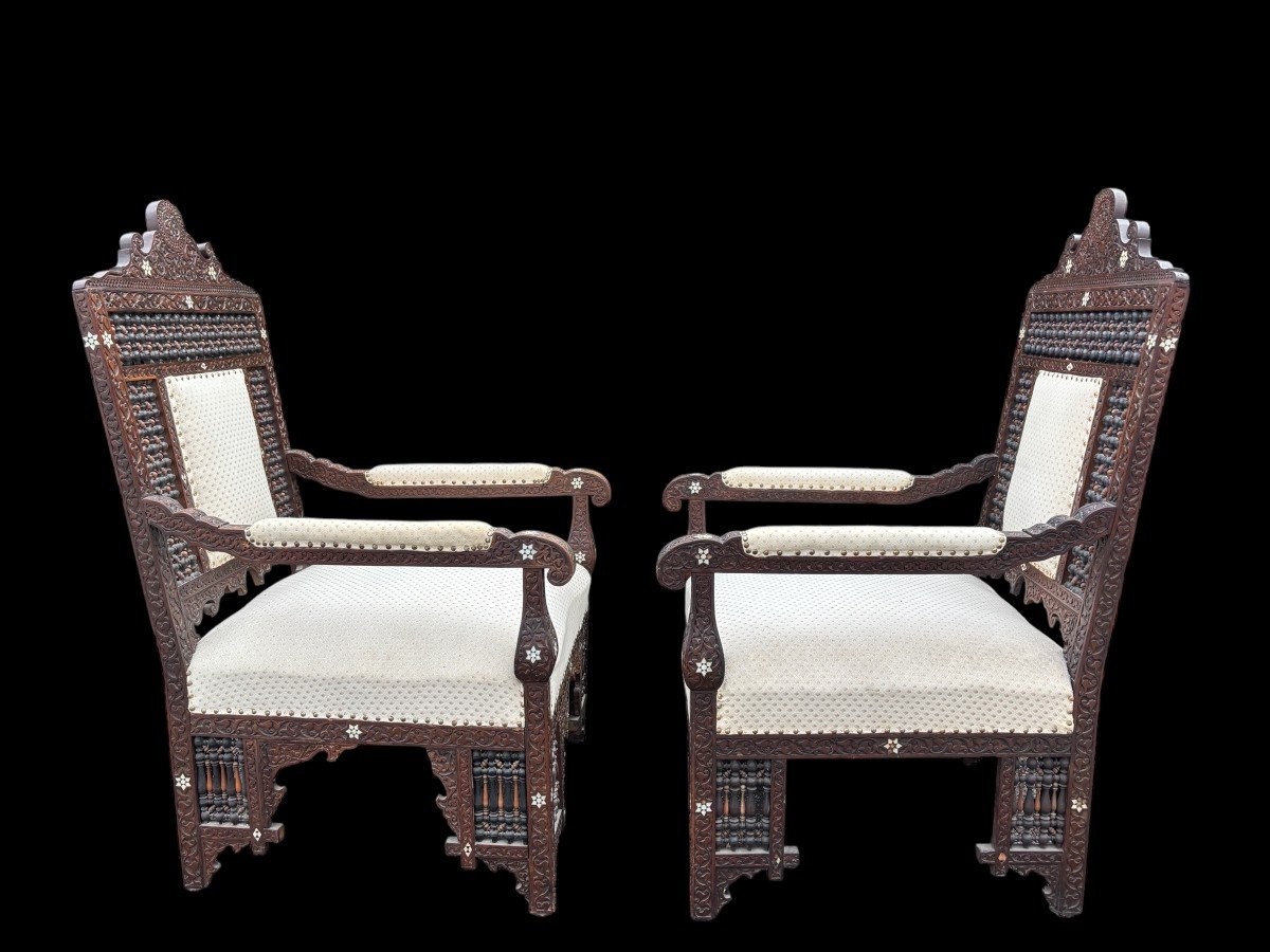 Pair of Carved Armchairs With Ebony And Mother Of Pearl Inlays. Syria, 19th century. Very decorative Orientalist armchairs upholstered in a beautiful fabric with cushion and scroll. Woodwork in good condition with a few chips and inlays due to age.