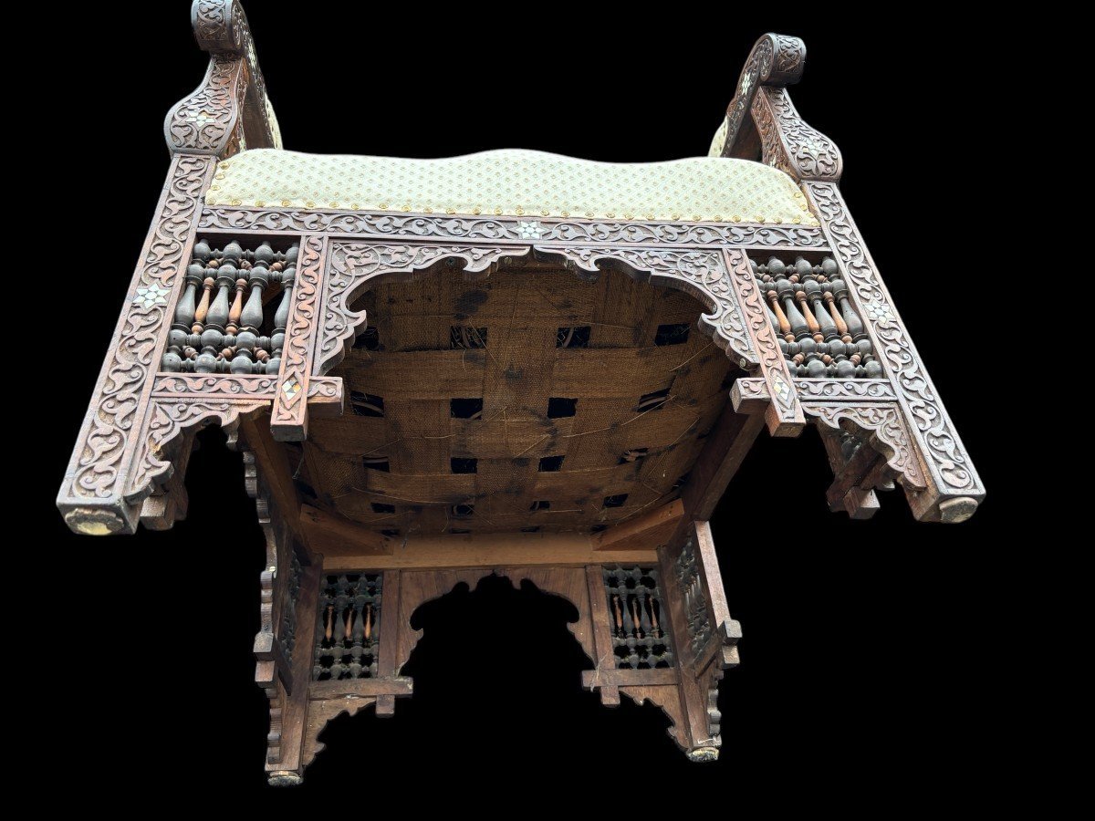 Pair of Carved Armchairs With Ebony And Mother Of Pearl Inlays. Syria, 19th century. Very decorative Orientalist armchairs upholstered in a beautiful fabric with cushion and scroll. Woodwork in good condition with a few chips and inlays due to age.