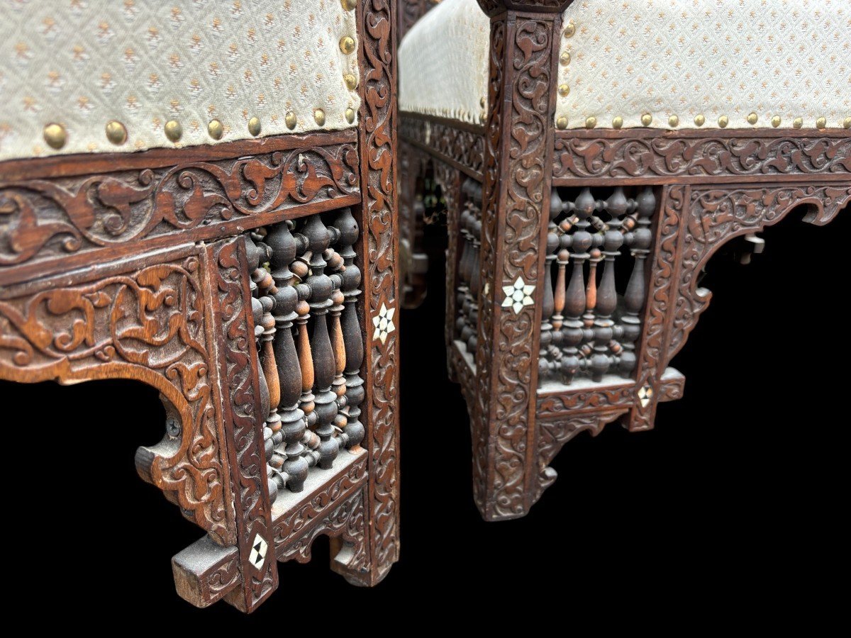 Pair of Carved Armchairs With Ebony And Mother Of Pearl Inlays. Syria, 19th century. Very decorative Orientalist armchairs upholstered in a beautiful fabric with cushion and scroll. Woodwork in good condition with a few chips and inlays due to age.