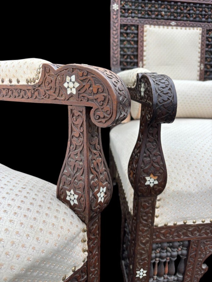 Pair of Carved Armchairs With Ebony And Mother Of Pearl Inlays. Syria, 19th century. Very decorative Orientalist armchairs upholstered in a beautiful fabric with cushion and scroll. Woodwork in good condition with a few chips and inlays due to age.