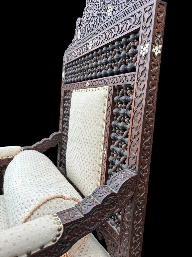 Pair of Carved Armchairs With Ebony And Mother Of Pearl Inlays. Syria, 19th century. Very decorative Orientalist armchairs upholstered in a beautiful fabric with cushion and scroll. Woodwork in good condition with a few chips and inlays due to age.