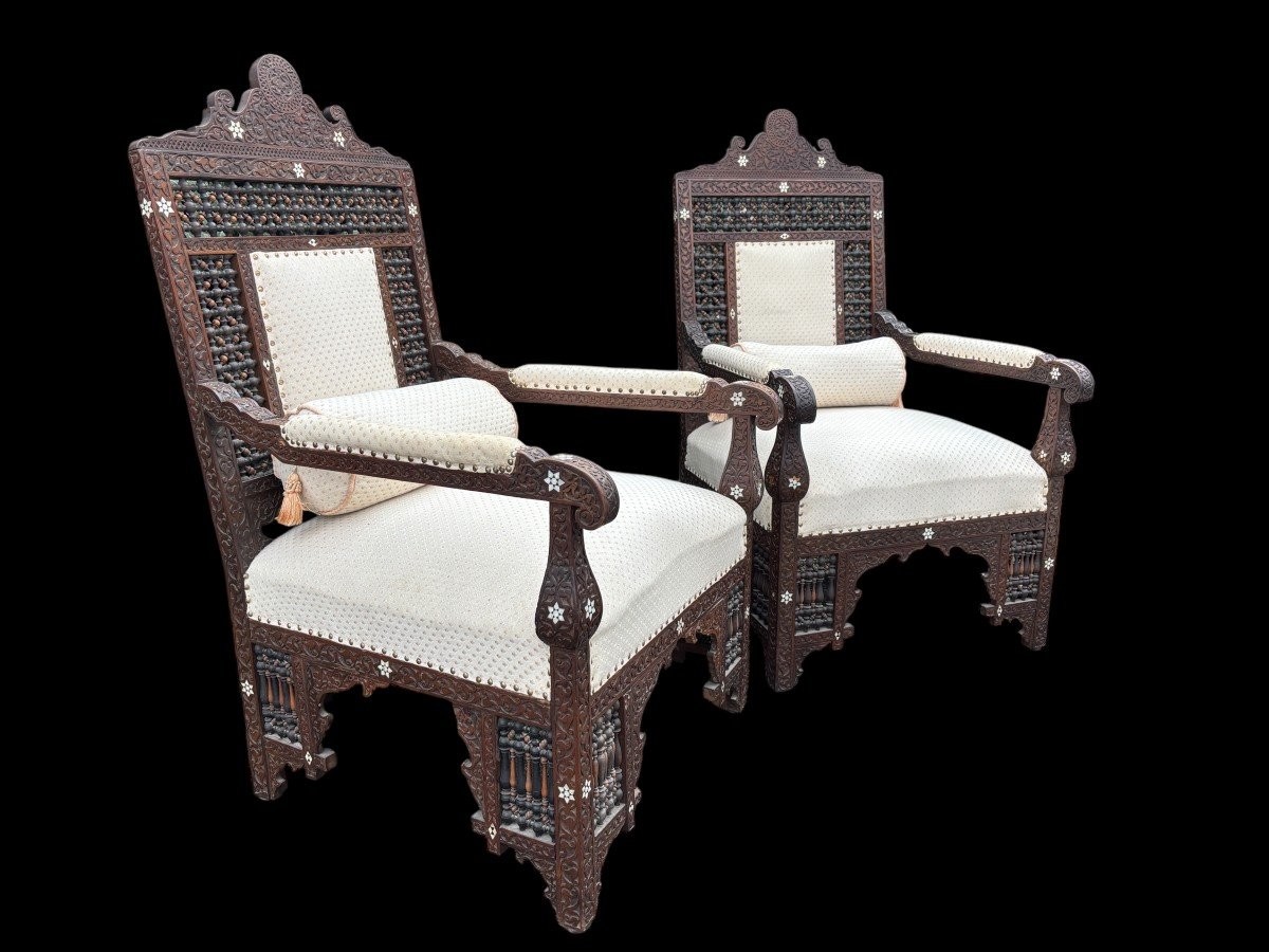 Pair of Carved Armchairs With Ebony And Mother Of Pearl Inlays. Syria, 19th century. Very decorative Orientalist armchairs upholstered in a beautiful fabric with cushion and scroll. Woodwork in good condition with a few chips and inlays due to age.