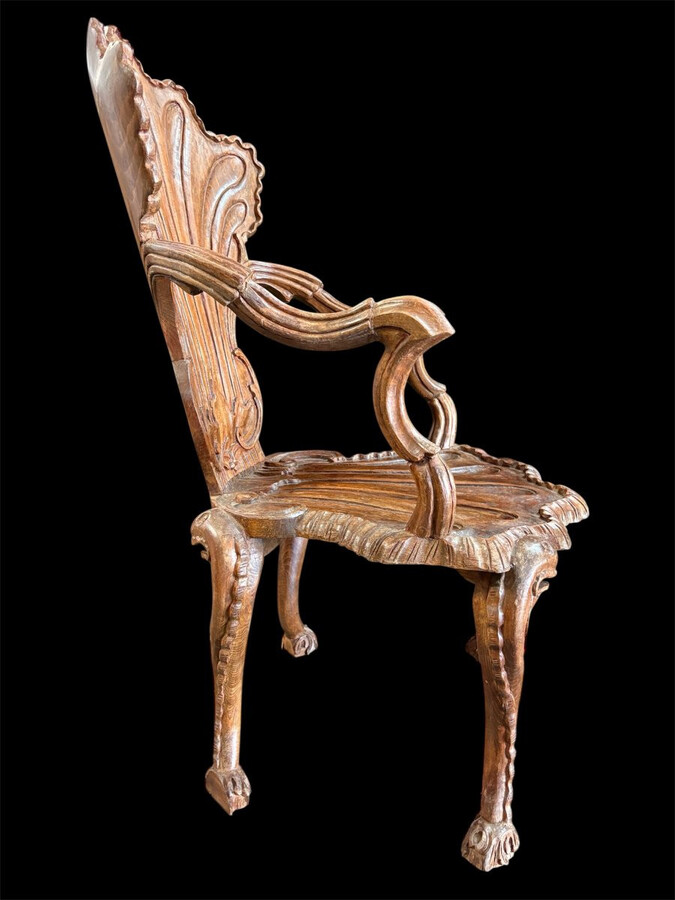 Pair Of Carved Walnut Cave Armchairs 20th C. A very fine pair of Venice carved walnut cave armchairs with a small table. The armchairs, shell-shaped, are all done in the typical style for decoration that was the fashion in Venice in the 19th century.
