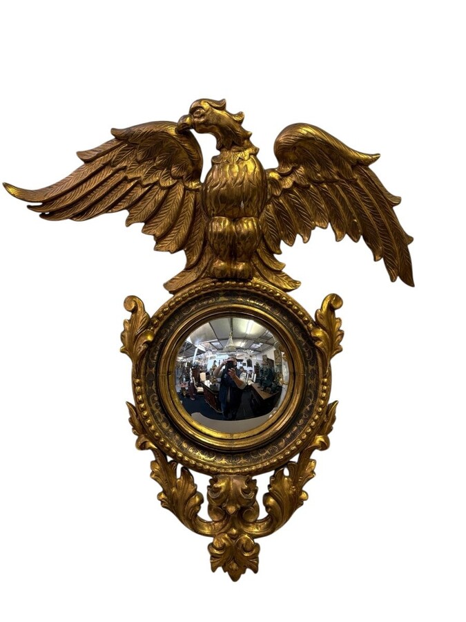 Pair of decorative ‘Eagles’ mirrors in gilded wood, late 19th century. Gilded wooden frame decorated with scrolls, paintings, a large gilded eagle and a convex mirror. Diameter of the curved mirror: 25 cm. 