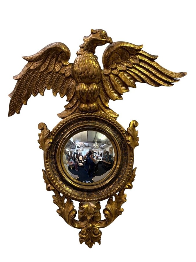 Pair of decorative ‘Eagles’ mirrors in gilded wood, late 19th century. Gilded wooden frame decorated with scrolls, paintings, a large gilded eagle and a convex mirror. Diameter of the curved mirror: 25 cm.