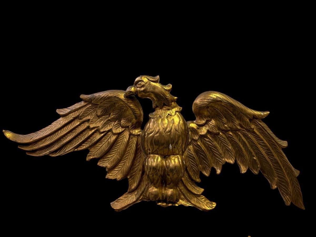 Pair of decorative ‘Eagles’ mirrors in gilded wood, late 19th century. Gilded wooden frame decorated with scrolls, paintings, a large gilded eagle and a convex mirror. Diameter of the curved mirror: 25 cm.
