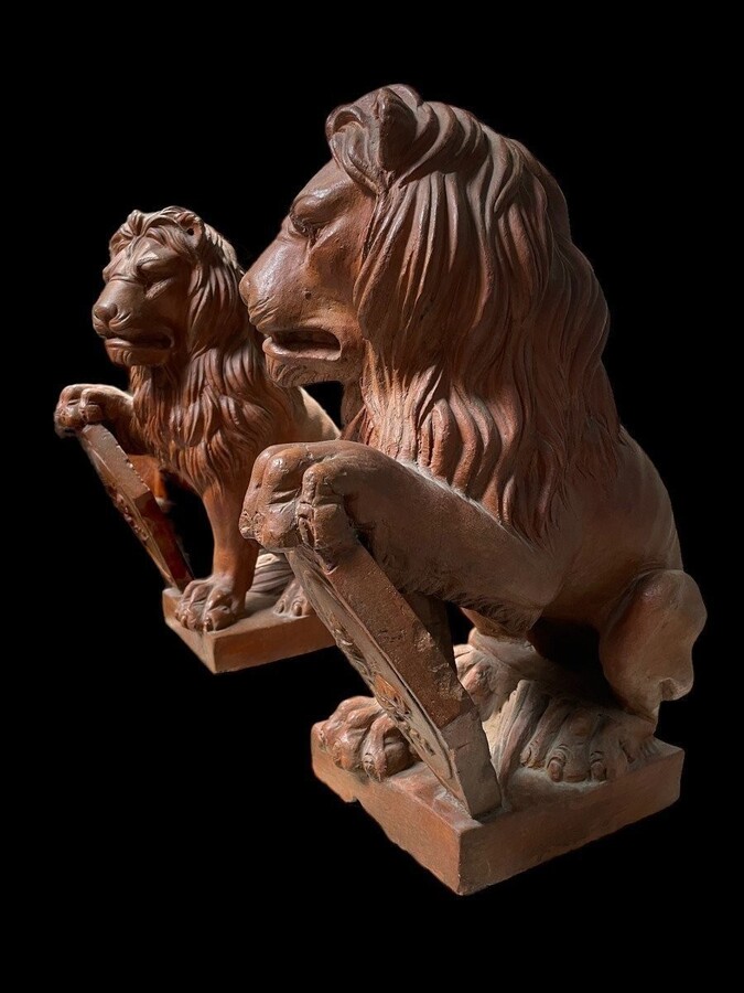 Pair of decorative lions with shields in terra cotta Beautiful pair of lions from Florence Italy from around 1900-1920. Both in good condition with some minor defects