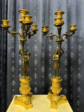 Pair of elegant bronze candelabra in the Empire style 19th century Pair of Empire period candelabra decorated with a winged man and a flame carrying a torch and four candles. They are both in very good condition 
