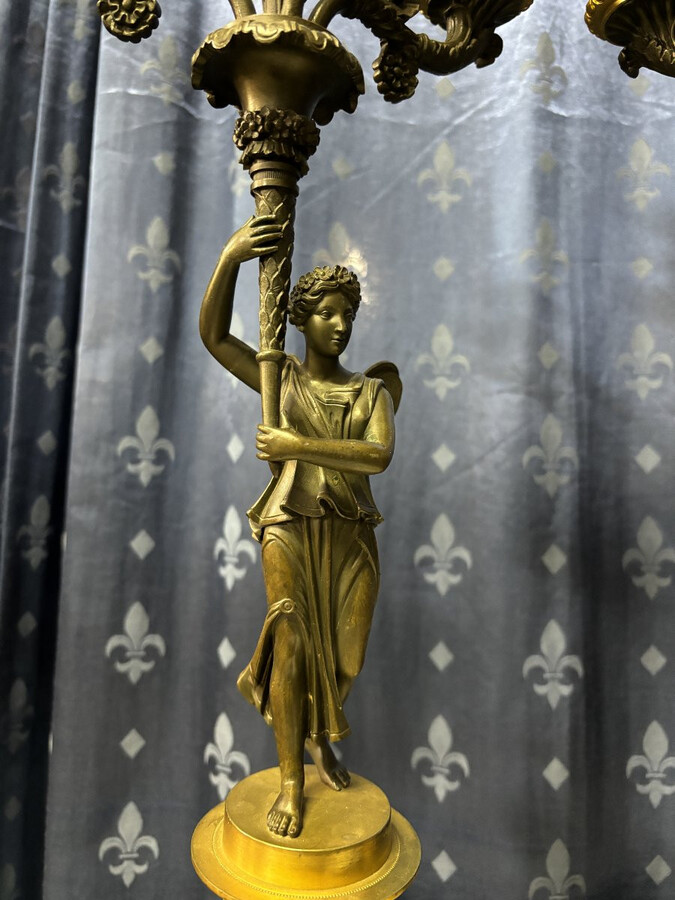 Pair of elegant bronze candelabra in the Empire style 19th century Pair of Empire period candelabra decorated with a winged man and a flame carrying a torch and four candles. They are both in very good condition 