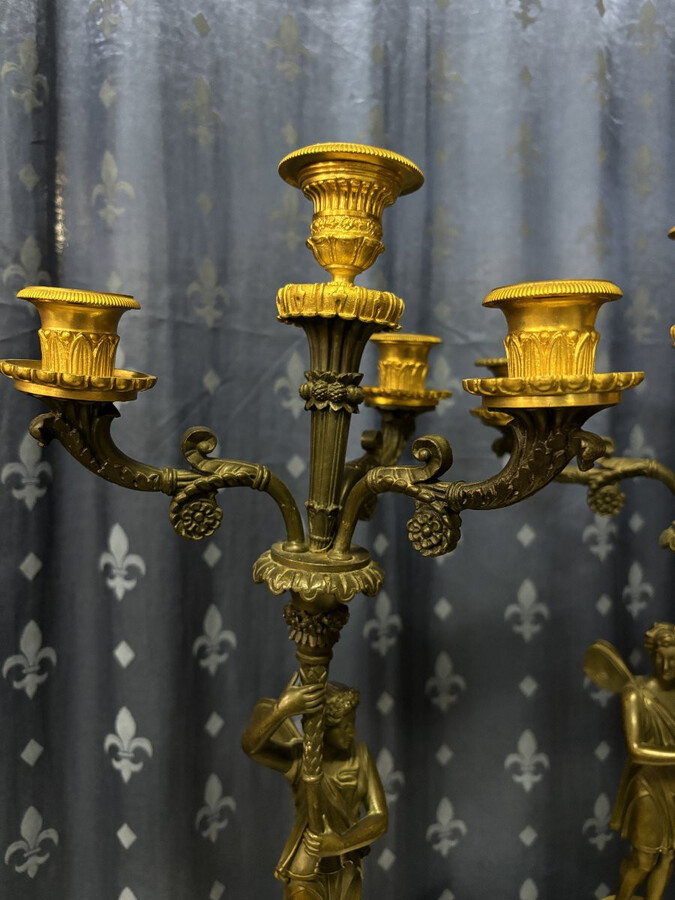 Pair of elegant bronze candelabra in the Empire style 19th century Pair of Empire period candelabra decorated with a winged man and a flame carrying a torch and four candles. They are both in very good condition 