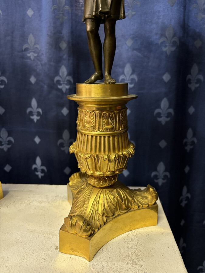 Pair of elegant bronze candelabra in the Empire style 19th century Pair of Empire period candelabra decorated with a winged man and a flame carrying a torch and four candles. They are both in very good condition 
