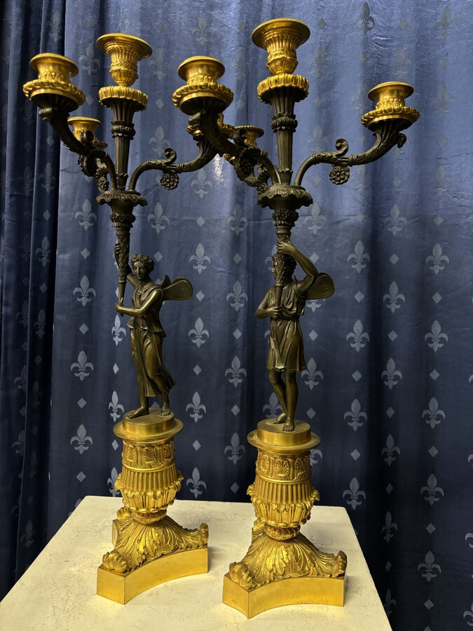 Pair of elegant bronze candelabra in the Empire style 19th century Pair of Empire period candelabra decorated with a winged man and a flame carrying a torch and four candles. They are both in very good condition 