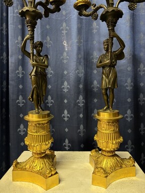 Pair of elegant bronze candelabra in the Empire style 19th century Pair of Empire period candelabra decorated with a winged man and a flame carrying a torch and four candles. They are both in very good condition
