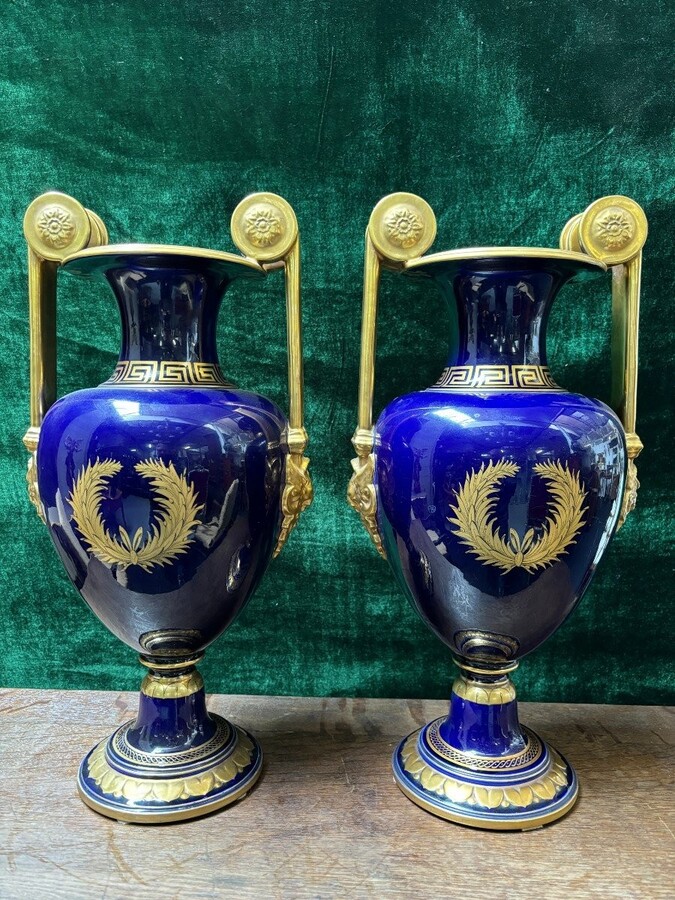 Pair of Empire style porcelain vases Sèvres , 20th Century Pair of vases with romantic paintings in blue and gilt tones. Signed by G.Etemod and underneath marked with Sèvres sign Dimensions : Height : 55 cm Width : 28 cm Diameter foot : 18 cm In