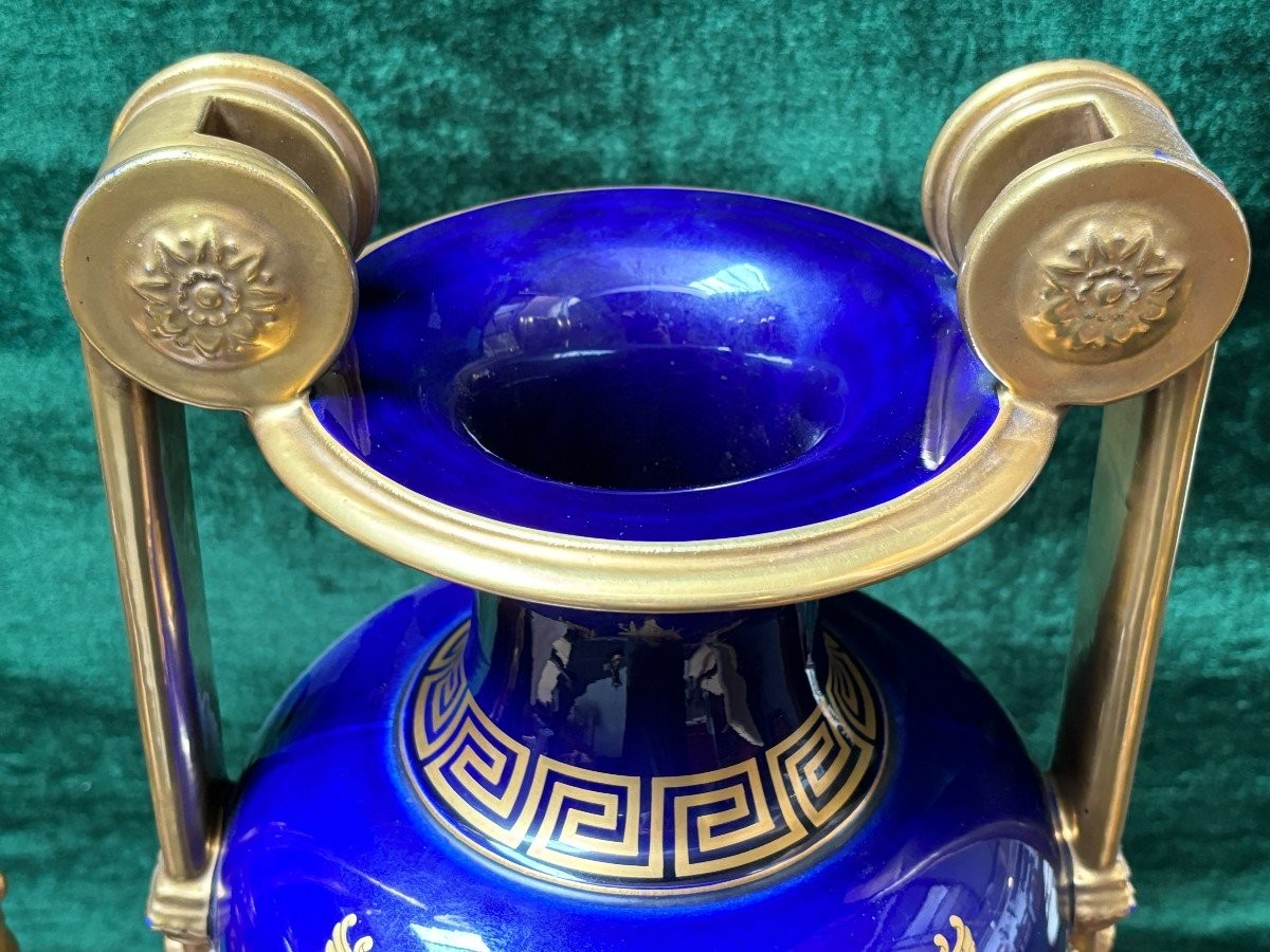 Pair of Empire style porcelain vases Sèvres , 20th Century Pair of vases with romantic paintings in blue and gilt tones. Signed by G.Etemod and underneath marked with Sèvres sign Dimensions : Height : 55 cm Width : 28 cm Diameter foot : 18 cm In
