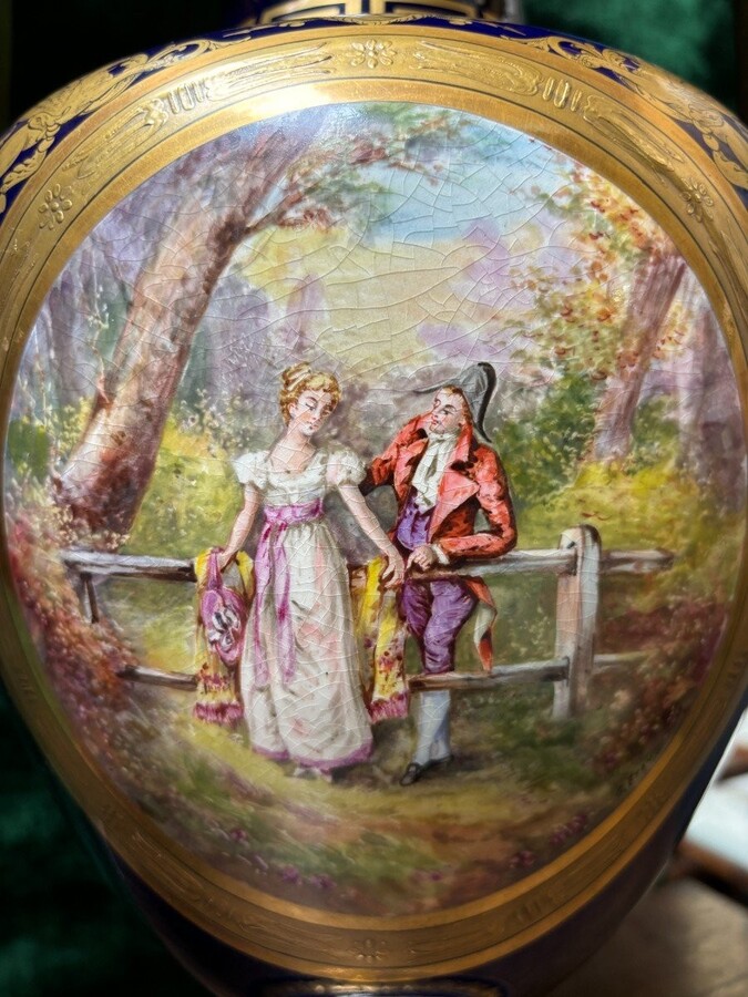 Pair of Empire style porcelain vases Sèvres , 20th Century Pair of vases with romantic paintings in blue and gilt tones. Signed by G.Etemod and underneath marked with Sèvres sign Dimensions : Height : 55 cm Width : 28 cm Diameter foot : 18 cm In