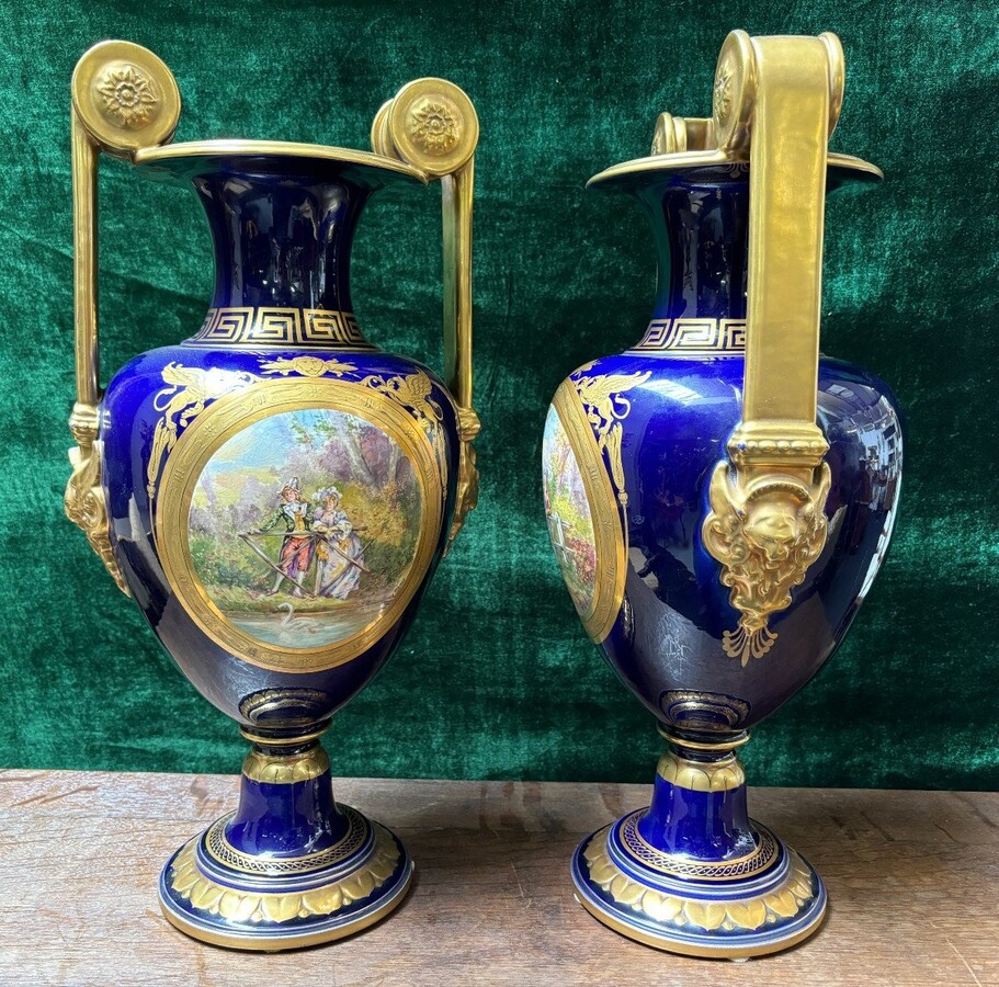 Pair of Empire style porcelain vases Sèvres , 20th Century Pair of vases with romantic paintings in blue and gilt tones. Signed by G.Etemod and underneath marked with Sèvres sign Dimensions : Height : 55 cm Width : 28 cm Diameter foot : 18 cm In