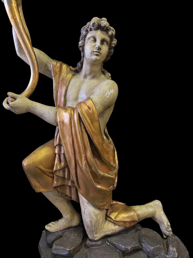 Pair of large 18th-century polychrome/gilded wooden sculptures/torch holders. 18th-century Italian decorative sculptures depicting two kneeling young men, draped in linen cloth and carrying a torch/candelabra. Both are in good condition with nor
