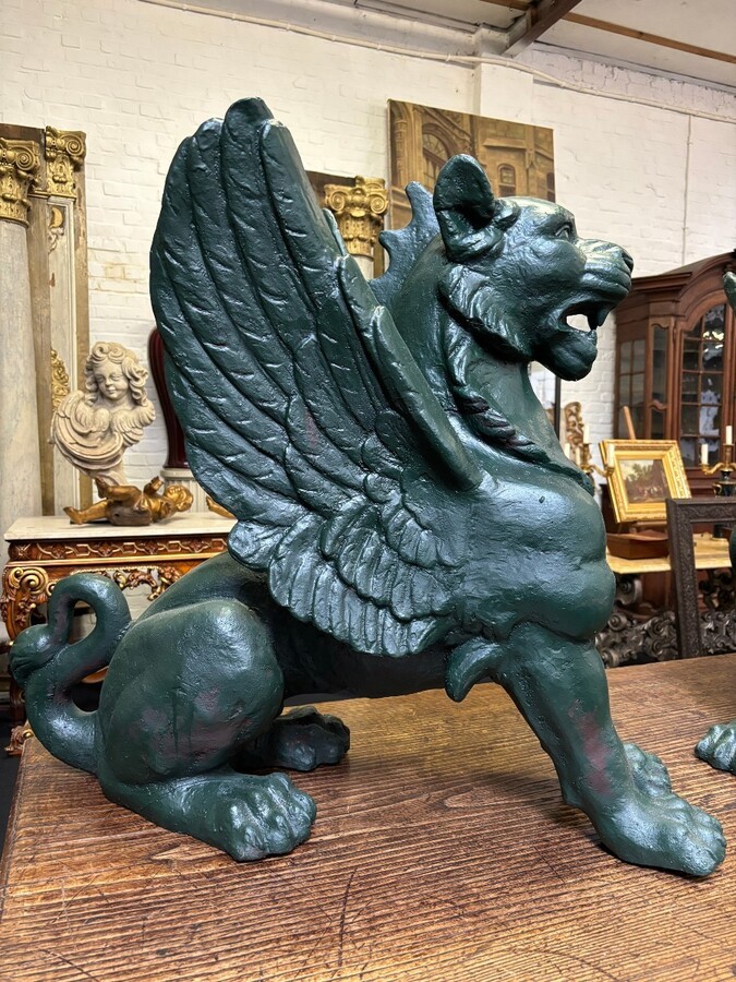 Pair of large, 20th-century cast iron, Empire-style mythological winged lions Highly decorative sculptures for gardens or interiors, with the following dimensions: Height: 83 cm Width: 47 cm Length: 89 cm