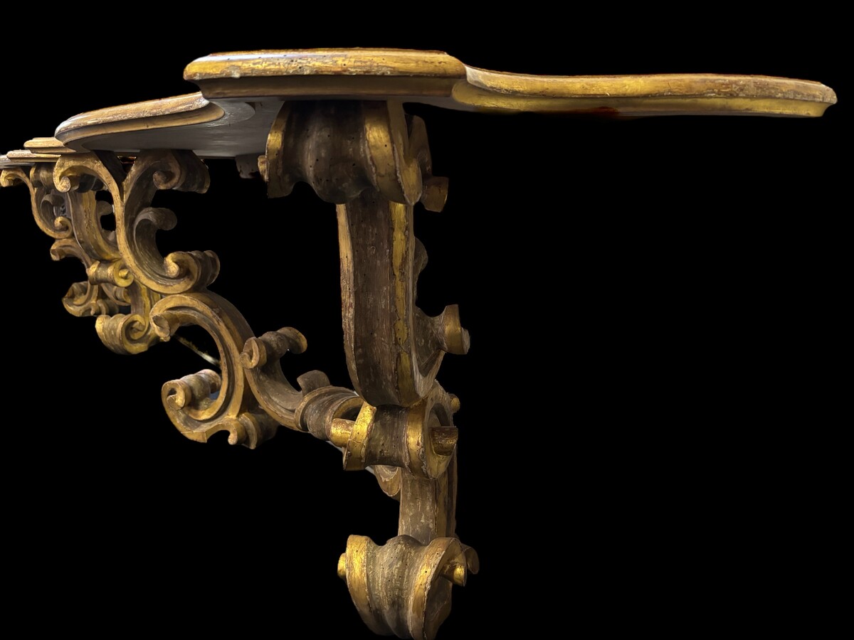 Pair of large consoles in gilt wood , Italian 18th century. Very decorative consoles decorated with large scrolls/ornaments in gilt wood with a painted top (tops in wood are recent , edge of table from the time). Dimensions : Width : 191 cm Height : 83,5