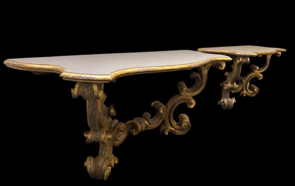 Pair of large consoles in gilt wood , Italian 18th century. Very decorative consoles decorated with large scrolls/ornaments in gilt wood with a painted top (tops in wood are recent , edge of table from the time). Dimensions : Width : 191 cm Height : 83,5