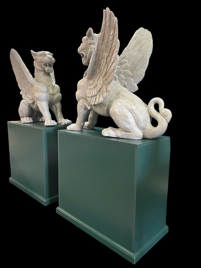 Pair of large Empire style mythological winged lions in cast iron 20thC. Very decorative sculptures for the garden or interior with the following dimensions: Height: 81 cm Width: 47 cm Length: 84 cm The wooden bases in the photo may be sold separately.