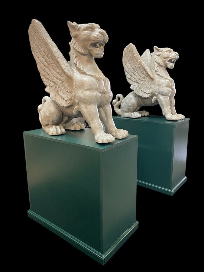 Pair of large Empire style mythological winged lions in cast iron 20thC. Very decorative sculptures for the garden or interior with the following dimensions: Height: 81 cm Width: 47 cm Length: 84 cm The wooden bases in the photo may be sold separately.